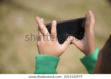 Kid hands playing with smartphone
