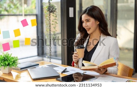 Businesswoman holding a cup of coffee and taking a break from working on her computer.