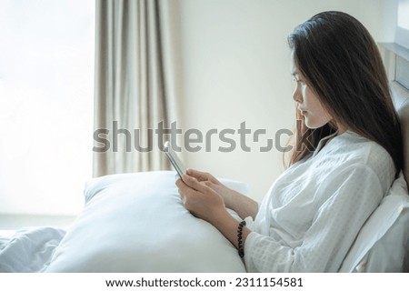 Sadness Asian woman using smartphone and waiting someone for call her back. Royalty-Free Stock Photo #2311154581