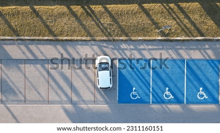 Outdoor car parking with handicapped symbol icon close to railway station.. Parking places reserved for disabled person. Aerial drone view. Royalty-Free Stock Photo #2311160151