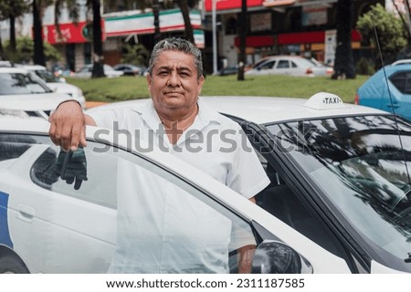 portrait of latin taxi driver senior man with car on background at city street in Mexico in Latin America, Hispanic adult people Royalty-Free Stock Photo #2311187585