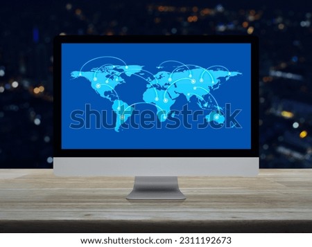 Connection line with global world map on computer screen on wooden table over blur night light city tower and skyscraper, Technology communication online, Elements of this image furnished by NASA