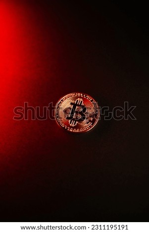 A vertical shot of a Bitcoin isolated on a red-to-black gradient background