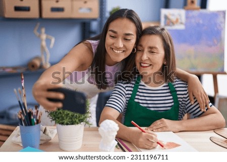 Two women artists drawing on notebook make selfie by smartphone at art studio