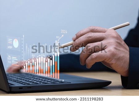 Businessman using laptop analyzing growth sales data graph on modern interface icons digital online marketing Solution analysis and content development related to global network connectivity. 