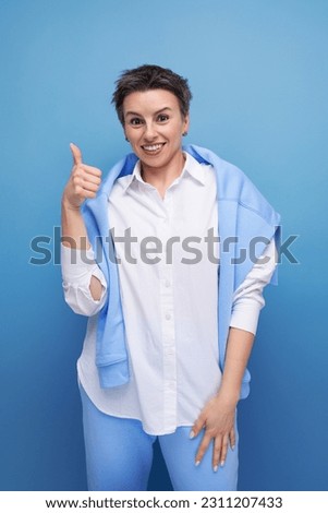 lucky happy young lady with tousled hair in a white shirt in an informal setting Royalty-Free Stock Photo #2311207433