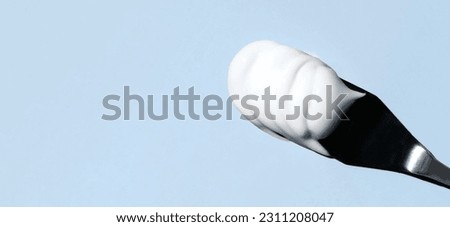 texture of cosmetic cream on a palette knife on a blue background with space for text Royalty-Free Stock Photo #2311208047