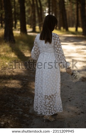 A woman in the forest enjoys the silence and beauty of nature.
