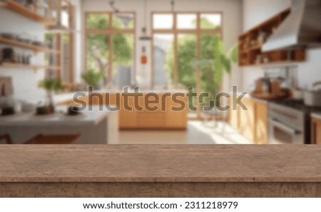 Wooden table top with blurry kitchen background of free space. Country style design kitchen with big windows and garden. 