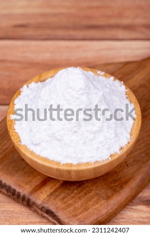 Powdered sugar on wooden background. Powdered or icing sugar in wood bowl Royalty-Free Stock Photo #2311242407