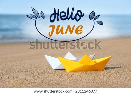 Hello June. Color paper boats on sandy beach near sea