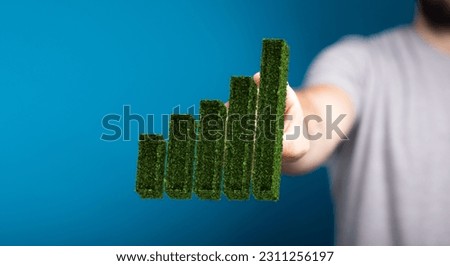 A man touching a green plant in form of a growing chart- green economy concept