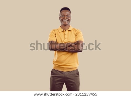 Portrait of confident young African American man isolated on brown studio background show leadership and power qualities. Smiling biracial male employee or worker pose with arms crossed. Royalty-Free Stock Photo #2311259455
