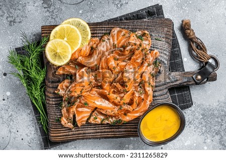 Gravlax Cured Salmon fillet with dill, salt and papper, lox. Gray background. Top view. Royalty-Free Stock Photo #2311265829