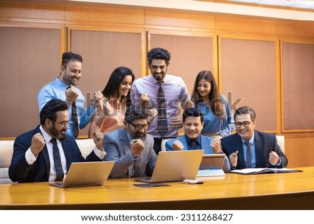 Indian businesspeople and employee giving happy expression after looking in laptop at office. Royalty-Free Stock Photo #2311268427
