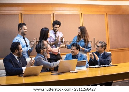 Indian businesspeople clapping hands for new project in company meeting at office. Royalty-Free Stock Photo #2311268429