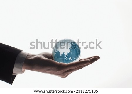 Businessman holding glass globe isolated on white background