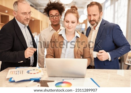 Creative team working together on laptop computer to develop website