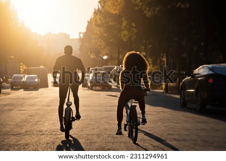 Two women with curly hair doing a bicycle lifestyle in very beautiful natural lighting. Lifestyle and sport concept