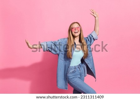 Photo portrait of attractive young teenager woman raise hands dance have fun wear trendy jeans clothes isolated on pink color background