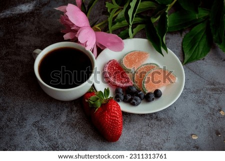 a cup of coffee, pink peonies and berries with marmalade