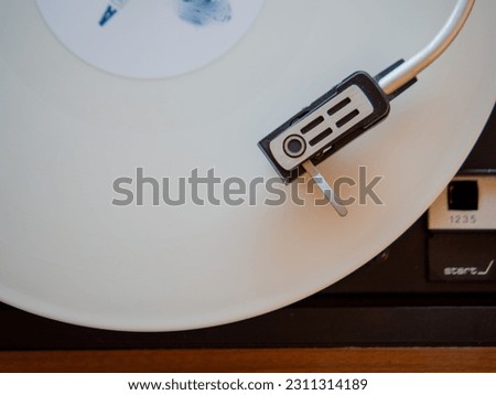 Detail of a needle on a track of a white vinyl record. Vintage turntable. Royalty-Free Stock Photo #2311314189