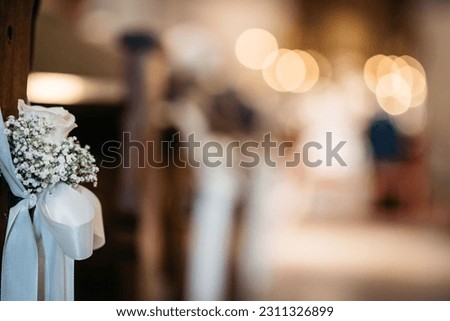 A white flower in the foreground against a church backdrop, perfect for any wedding related project