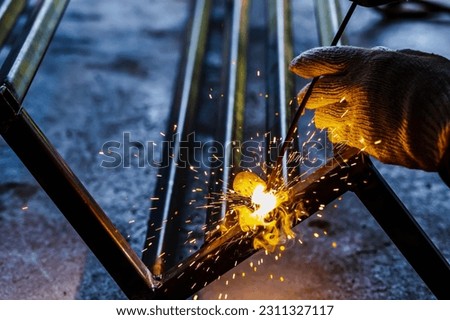 Close up welding man working on iron welding in construction site Royalty-Free Stock Photo #2311327117