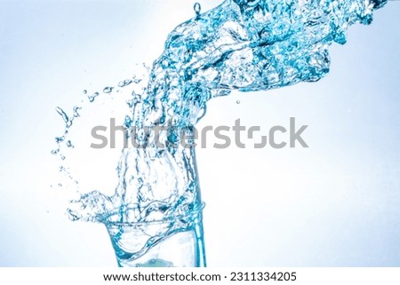 Drinking water splashing from the glass on white background