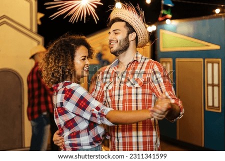 Couple dancing to Festa Junina, a lively Brazilian June festival with music, decorations, and joyful dances, showcasing Brazil's vibrant cultural traditions Royalty-Free Stock Photo #2311341599