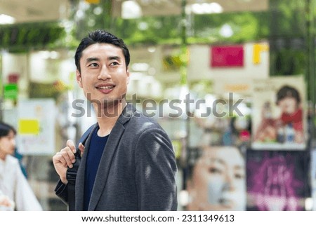 Asian man standing in the street.