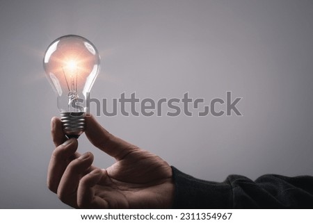 Man hand holding light bulb brain metaverse technology icon, studio shot. Virtual gadgets for entertainment, work, free time and study. Idea creative by using phone concept.