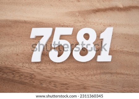 White number 7581 on a brown and light brown wooden background.