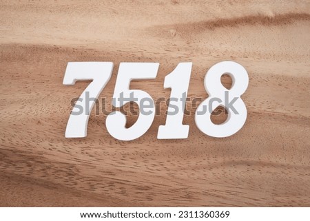 White number 7518 on a brown and light brown wooden background.