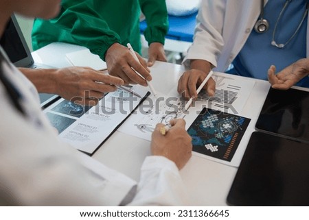 Medical team meeting with surgical surgeon in white coats and surgical team discussing patient condition documenting successful medical health treatment. concept of working with medical team Royalty-Free Stock Photo #2311366645