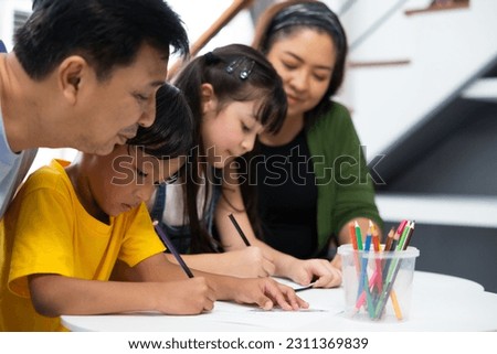 Family drawing a colorful pictures together at home. Happy children brother and sister drawing at home, family time togetherness