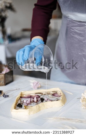 Epoxy Resin Art. Creating Art with Resin on workshop. The art process of creating epoxy resin handmade staff in art studio. Royalty-Free Stock Photo #2311388927