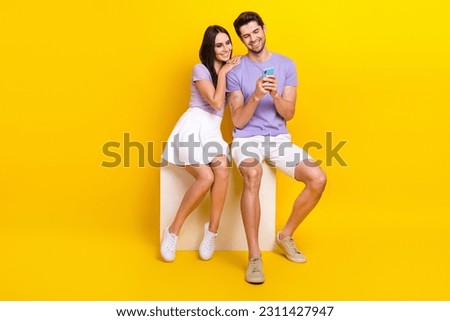 Full size photo of attractive woman man sit cube booking honeymoon tickets wear trendy purple clothes isolated on yellow color background