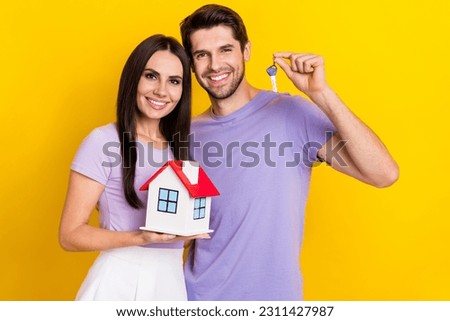 Photo portrait of pretty young girl male hold key small house buyer investing wear trendy purple outfit isolated on yellow color background