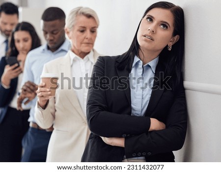 Tired, waiting room and woman in line for business interview, job application or hiring opportunity in corporate company. Group, people and frustrated person in queue, appointment and anxious time Royalty-Free Stock Photo #2311432077