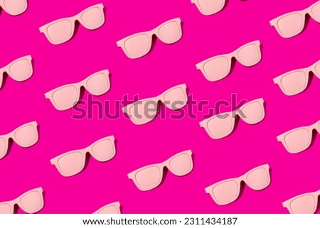 Pink sunglasses on vibrant magenta colored background. Summer eyeglasses pattern. Vibrant colors.
