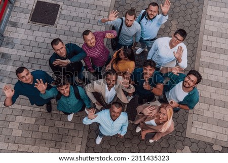 A top view photo of group of businessmen and colleagues standing together, looking towards the camera, symbolizing unity and teamwork.