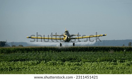 Air Tractor 802 airplane spraying fungicide on a soybean field in the Midwest. This airplane carries a payload of 800 gallons in the hopper. Royalty-Free Stock Photo #2311451421