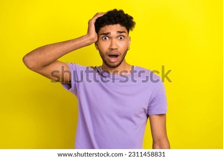 Portrait of impressed confused person arm touch head open mouth speechless staring isolated on yellow color background