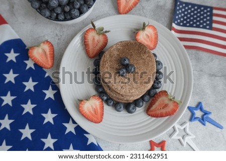 Pancakes with forest fruits berries on beautiful table. Healthy breakfast. Blueberries and strawberry on pancakes. Independence Day 4th of July. 