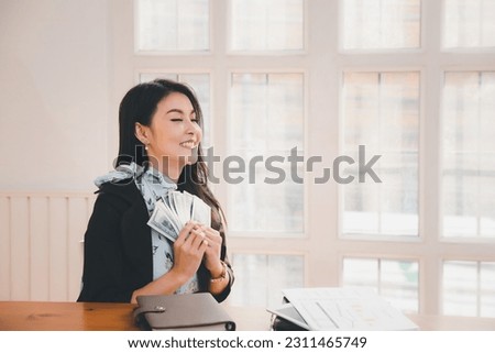 Beautiful woman waving money in good mood she lucky and successful of her business.