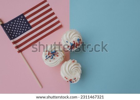 Cupcakes stand on a colored background. Next to the American flag