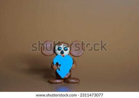 A toy cheburashka with a blue heart. The blue color symbolizes the support of children with autism.