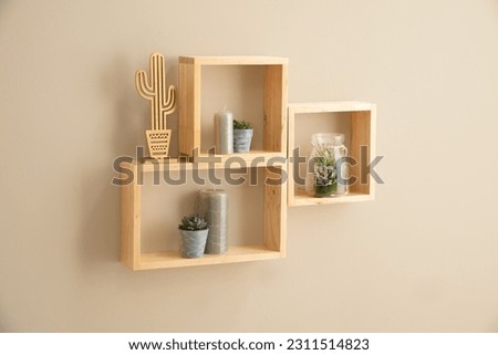 An aesthetically pleasing still-life featuring a selection of small wooden cube shelves, a cactus plant and a glass vase Royalty-Free Stock Photo #2311514823