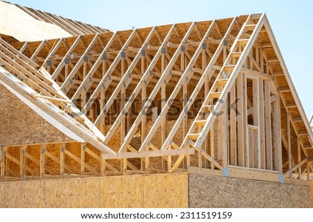 plywood house rafters roof wooden house framework building site boatd Royalty-Free Stock Photo #2311519159